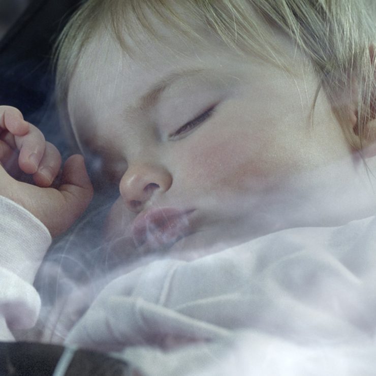 Baby asleep with smoke around it