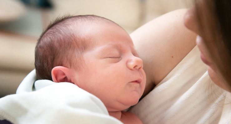 Mother cradling newborn baby