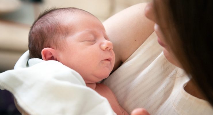 Mother cradling newborn baby