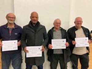 Four men in a row holding up their smokefree certificates