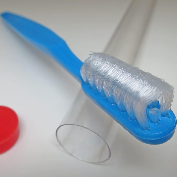 Close up image of a collis curve toothbrush, showing the three rows of bristles for brushing all sides of teeth simultaneously.