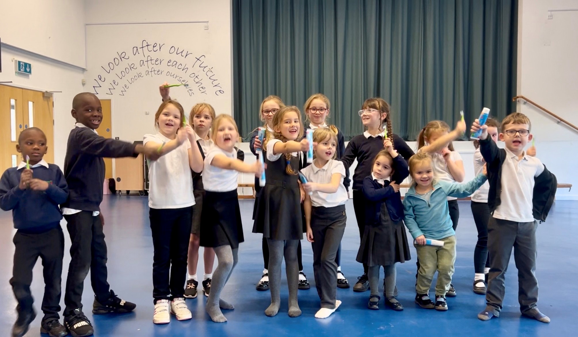 Children showing their toothbrushes and toothpastes