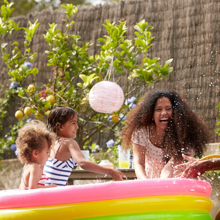 Family playing in paddling pool
