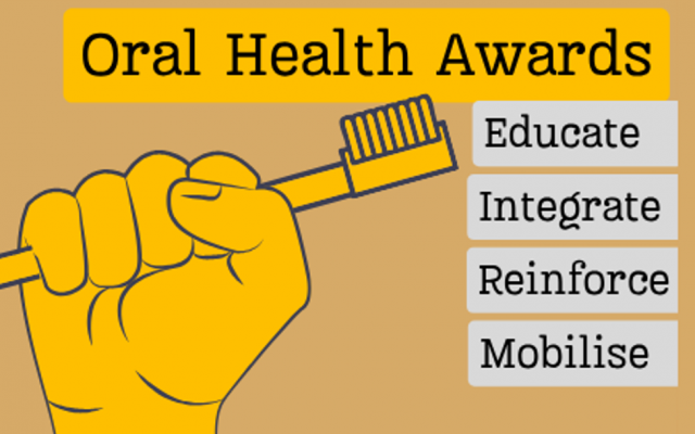 Golden fist holds golden toothbrush with title "Oral Health Awards" and the award stands "Educate, Integrate, Reinforce and Mobilise" listed on plaques.