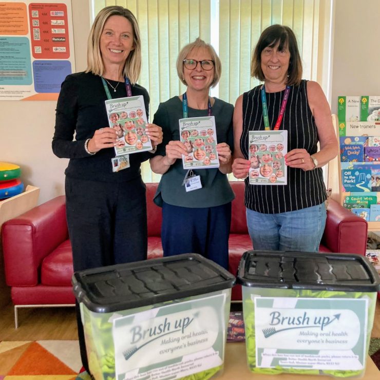 A team of Brush Up Champions with their training manuals and toothbrush packs.