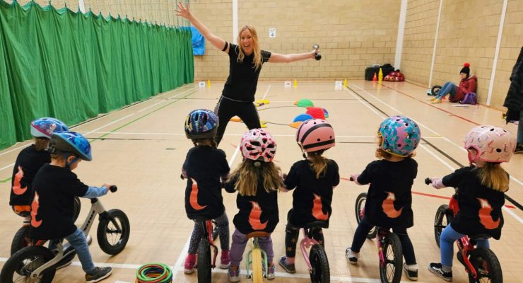 Children on bikes in a sports hall