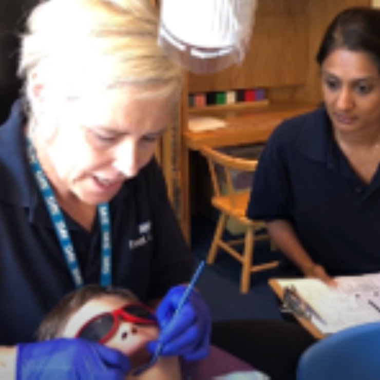 Dentist looks in child's mouth in school